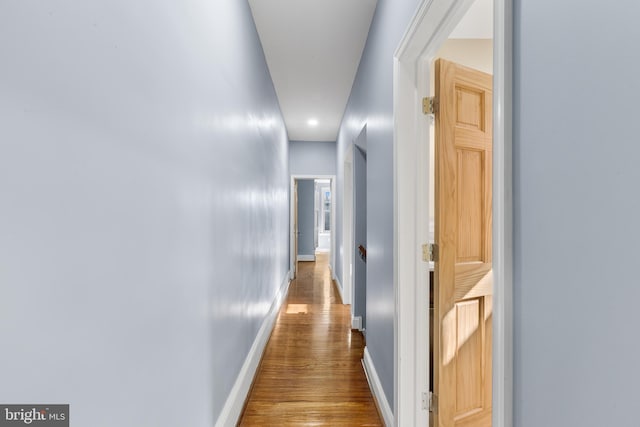 hallway with hardwood / wood-style flooring