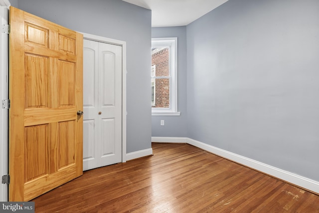 unfurnished bedroom with wood-type flooring and a closet