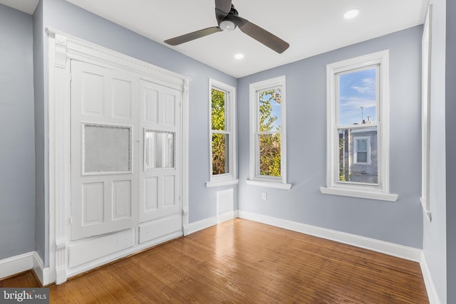 unfurnished bedroom featuring a closet, hardwood / wood-style floors, and ceiling fan