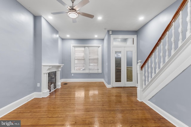 unfurnished living room featuring hardwood / wood-style flooring and ceiling fan