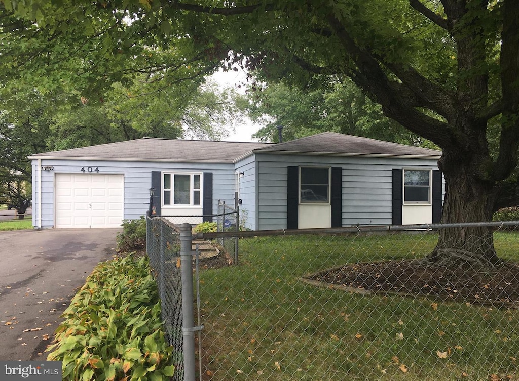 single story home featuring a garage and a front yard