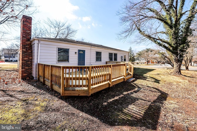 rear view of house featuring a wooden deck