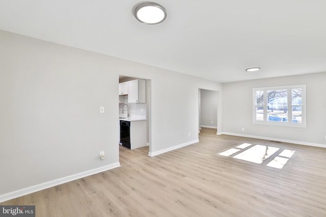 unfurnished living room with sink and light hardwood / wood-style flooring