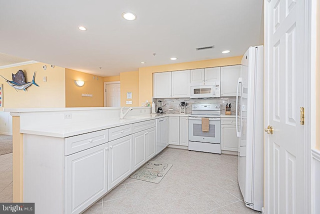 kitchen featuring kitchen peninsula, tasteful backsplash, white cabinetry, sink, and white appliances