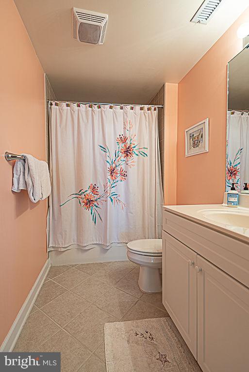 full bathroom featuring vanity, toilet, tile patterned floors, and shower / bath combo