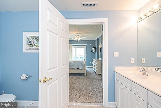 bathroom featuring vanity, a textured ceiling, toilet, and ceiling fan