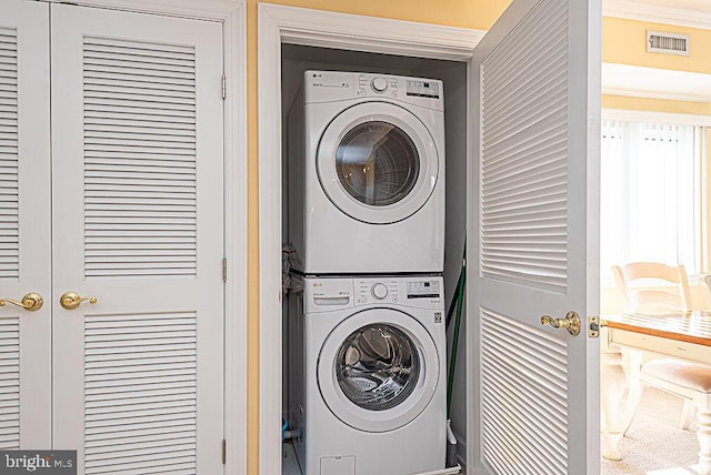 clothes washing area with stacked washer and dryer