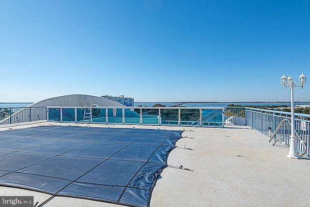 view of swimming pool featuring a water view