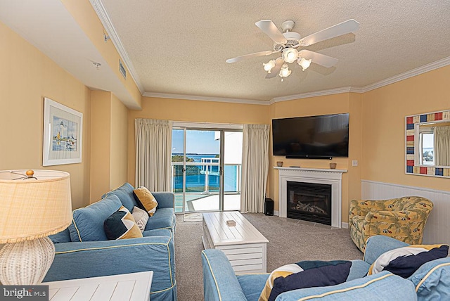 carpeted living room featuring ceiling fan, a textured ceiling, and ornamental molding