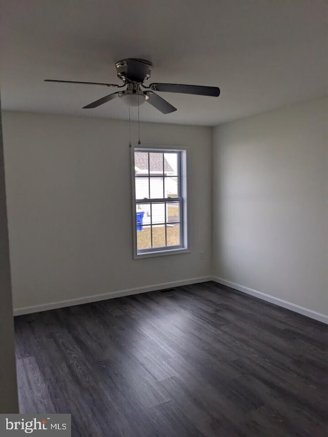 empty room with dark hardwood / wood-style flooring and ceiling fan