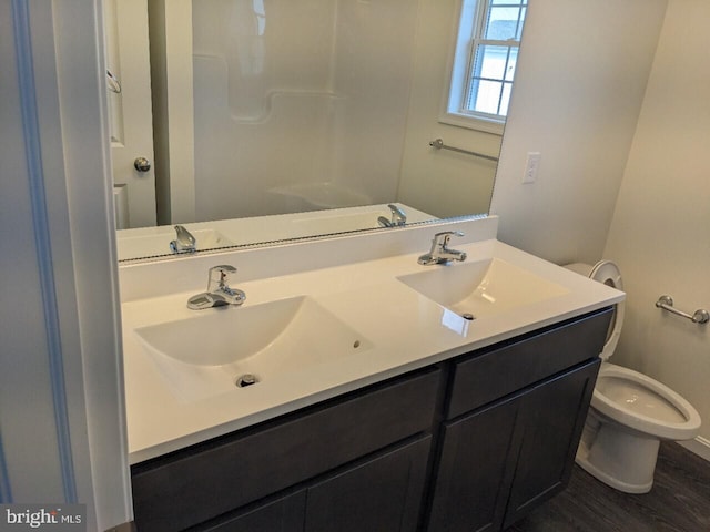 bathroom with toilet, vanity, and hardwood / wood-style flooring