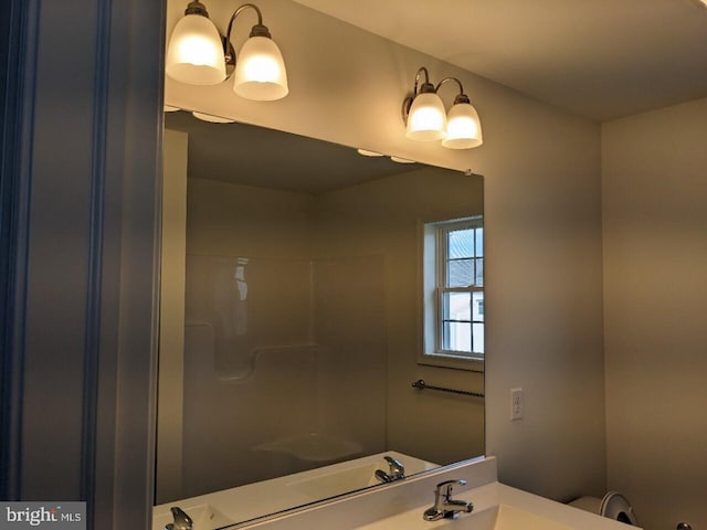 bathroom featuring walk in shower and vanity