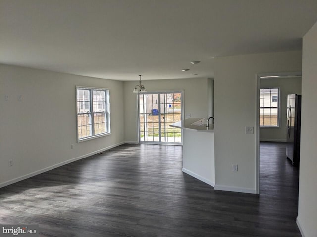 empty room featuring a notable chandelier and dark hardwood / wood-style floors