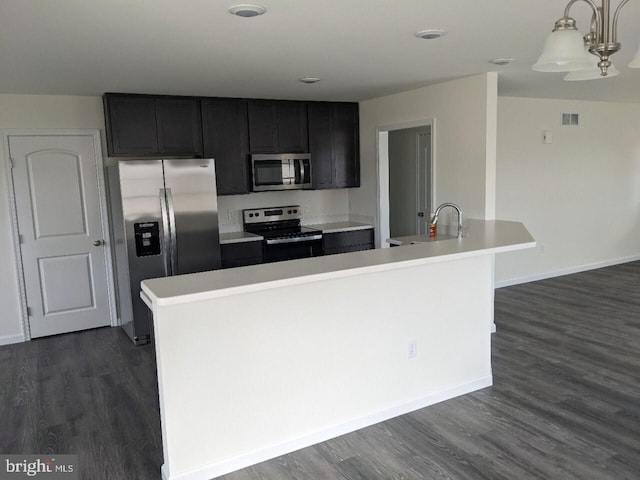 kitchen featuring dark hardwood / wood-style floors, a center island with sink, sink, and appliances with stainless steel finishes