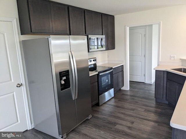 kitchen with dark wood-type flooring, sink, dark brown cabinets, and stainless steel appliances