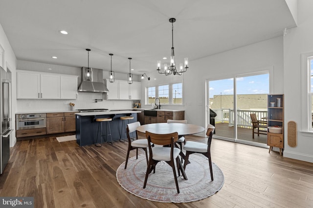 dining space with sink, a notable chandelier, and dark hardwood / wood-style flooring