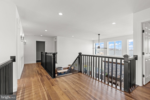 corridor featuring a notable chandelier and wood-type flooring