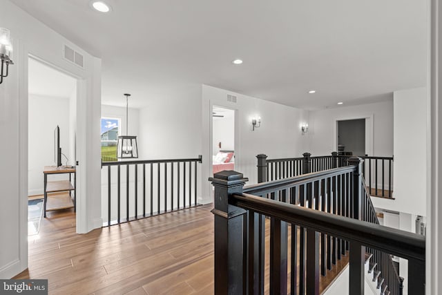 hallway featuring hardwood / wood-style flooring and a chandelier