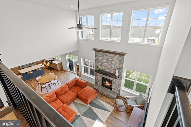 living room featuring ceiling fan, wood-type flooring, and a fireplace