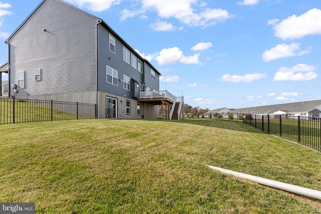 rear view of house featuring a deck and a yard