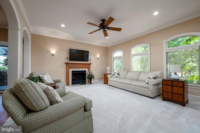 living room with light carpet, ornamental molding, and ceiling fan