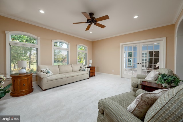 carpeted living room featuring ornamental molding, french doors, and ceiling fan