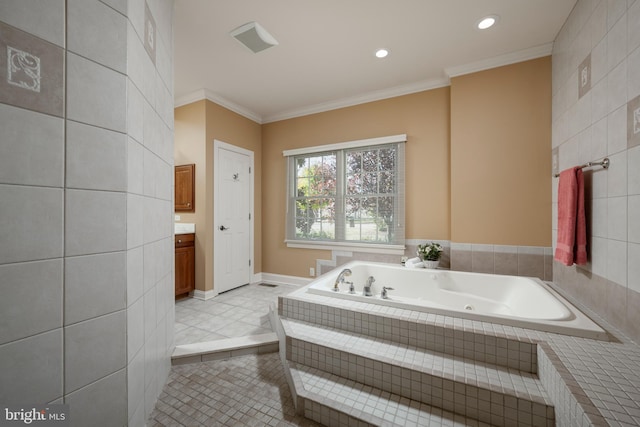 bathroom with vanity, ornamental molding, tiled tub, and tile patterned floors