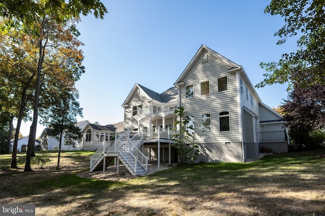 rear view of house featuring a deck and a lawn