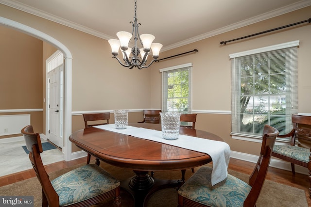 dining area featuring ornamental molding, a notable chandelier, and light hardwood / wood-style floors