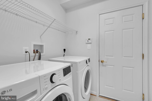 laundry room featuring independent washer and dryer and light tile patterned flooring