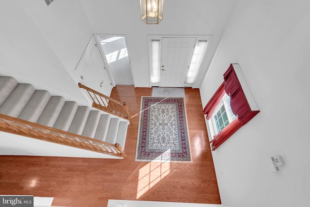 foyer entrance with wood-type flooring and a high ceiling