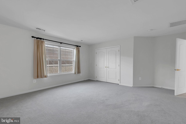 unfurnished bedroom featuring a closet and light colored carpet