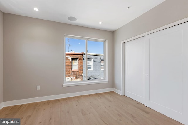 unfurnished bedroom featuring a closet and light wood-type flooring