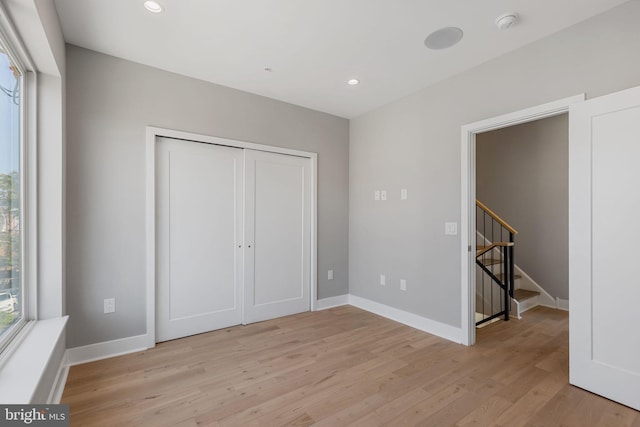 unfurnished bedroom with a closet and light wood-type flooring