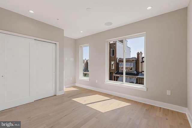 unfurnished bedroom featuring a closet and light hardwood / wood-style floors