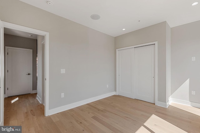 unfurnished bedroom featuring a closet and light hardwood / wood-style floors