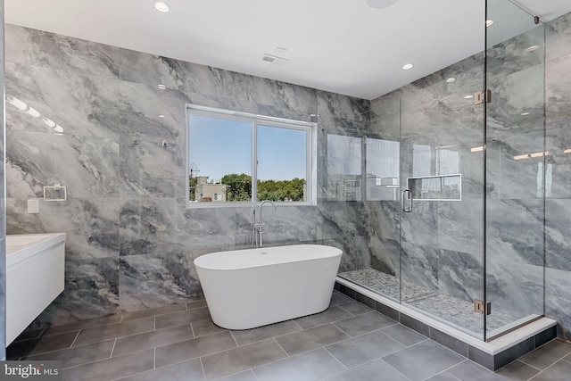 bathroom featuring vanity, tile walls, separate shower and tub, and tile patterned flooring