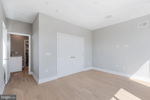 unfurnished bedroom featuring a closet and light hardwood / wood-style floors