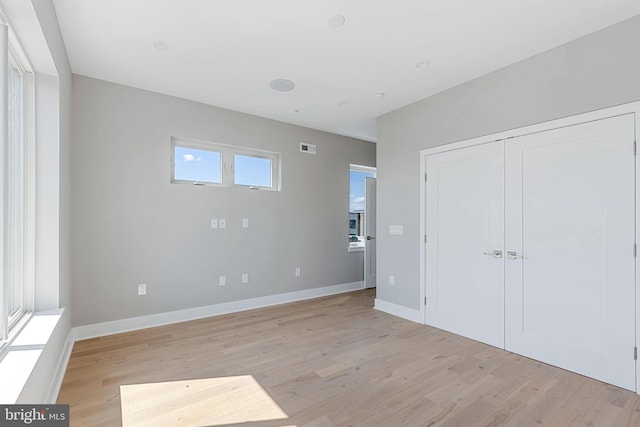 unfurnished bedroom featuring a closet and light wood-type flooring