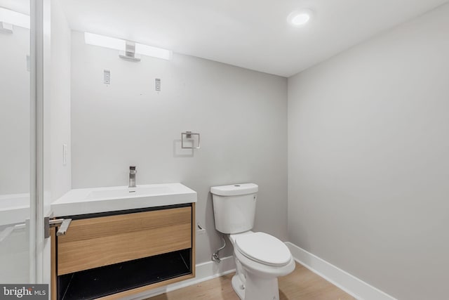 bathroom featuring vanity, toilet, and hardwood / wood-style floors