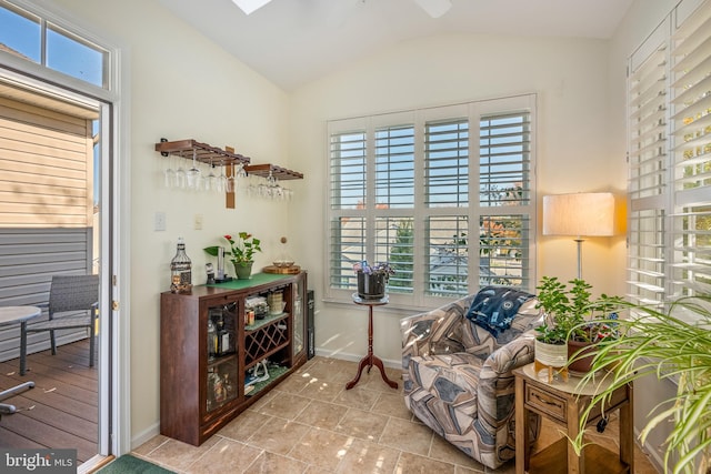 sitting room featuring vaulted ceiling, light tile patterned floors, and plenty of natural light