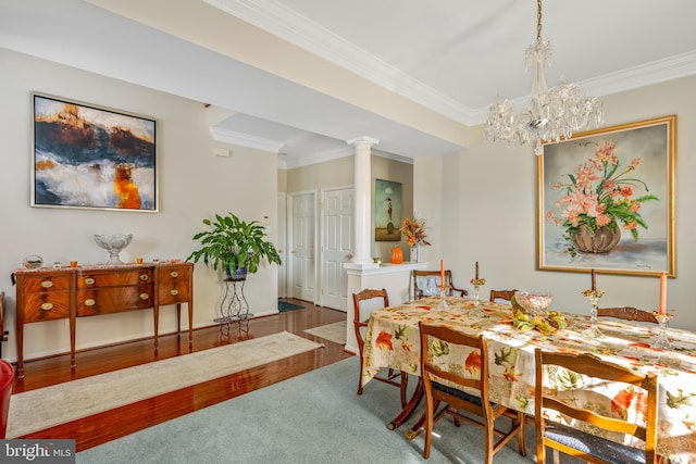 carpeted dining space with crown molding and decorative columns