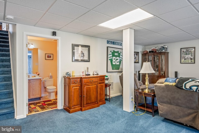 carpeted living room with a drop ceiling