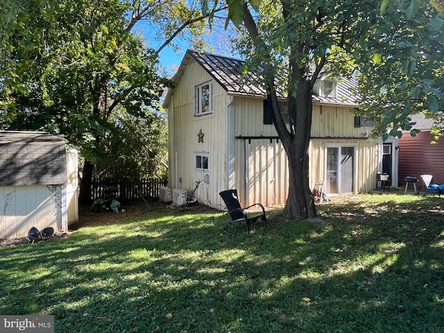 back of house with a yard and ac unit