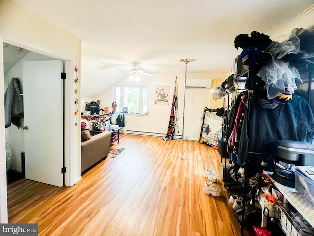 miscellaneous room featuring baseboard heating, wood-type flooring, ceiling fan, and vaulted ceiling