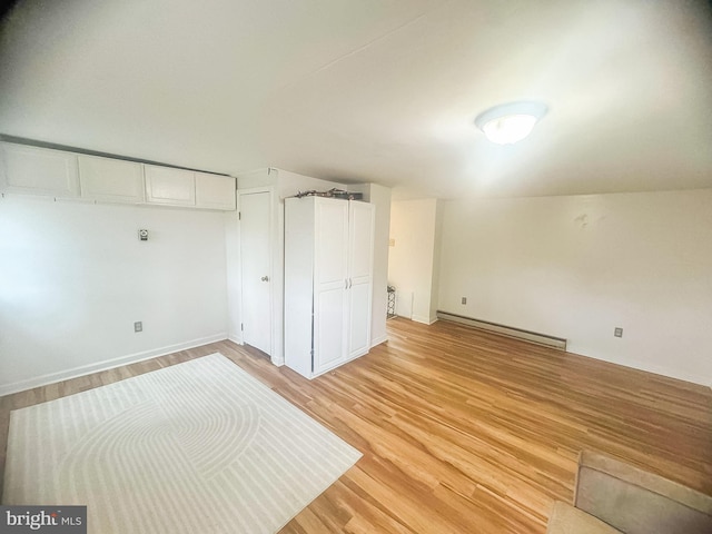 unfurnished bedroom featuring light wood-type flooring and a baseboard radiator