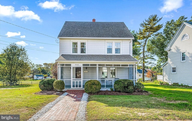 view of front of house featuring a chimney, a porch, a shingled roof, and a front lawn