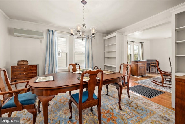 dining area featuring a wealth of natural light, light wood-type flooring, an AC wall unit, and a notable chandelier