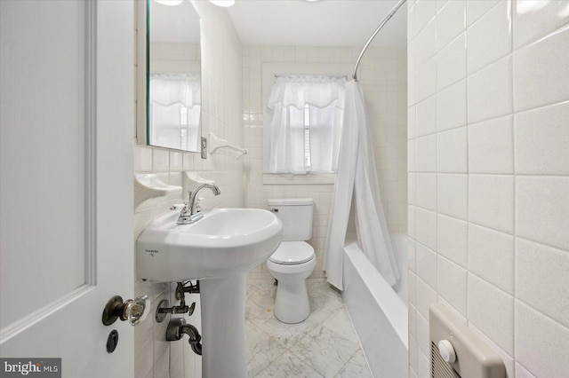 bathroom featuring toilet, tile walls, and shower / tub combo with curtain