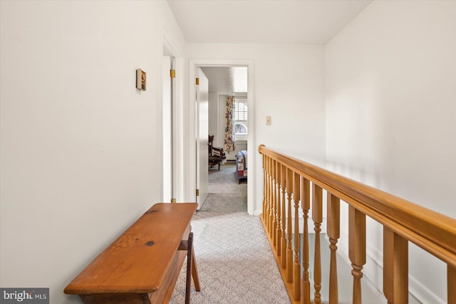 hall with an upstairs landing and carpet